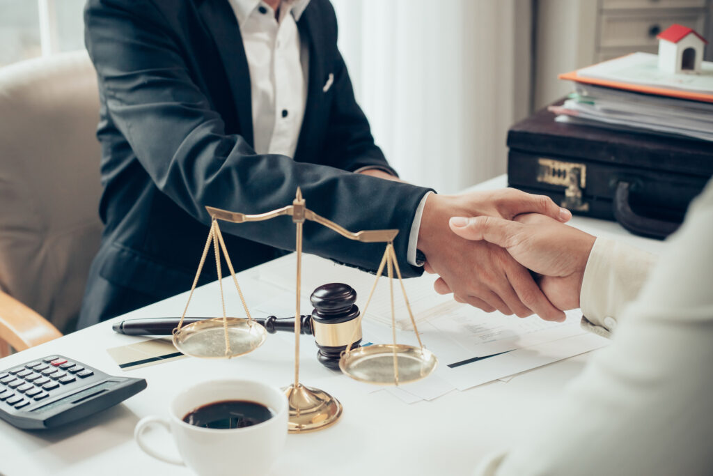 Two people exchanging an offer of settlement at a desk